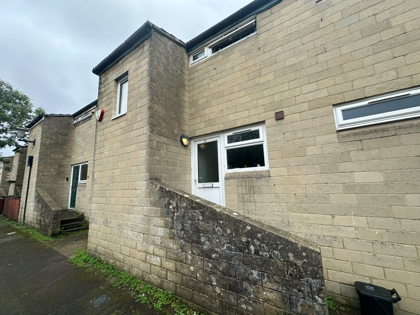 Front of 27 Loxton Drive, pale stone terrace with a white front door and a low stone wall