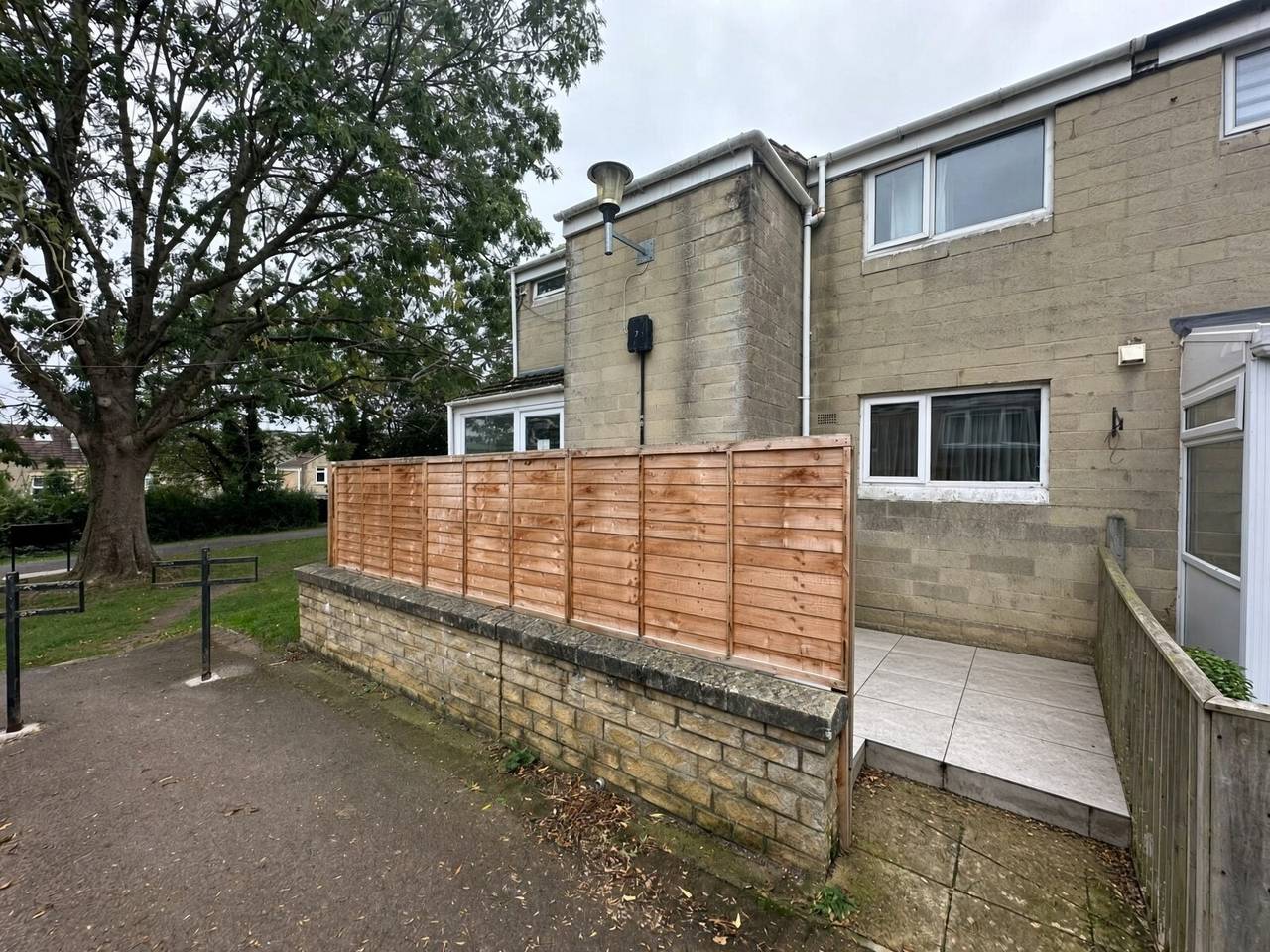 Front of 38 King George's Road, stone house with new fence and paved patio beside the footpath