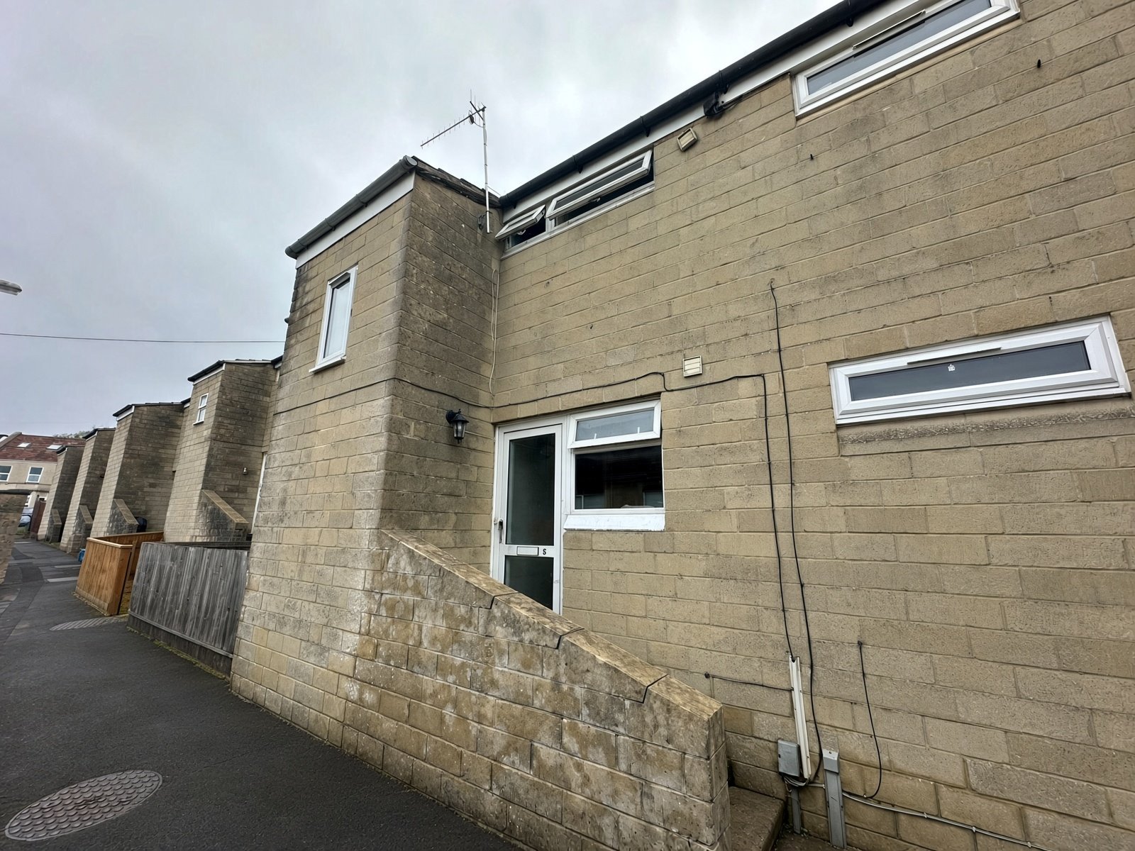 Front of 5 Rooksbridge Walk, pale stone terrace beside a paved footpath