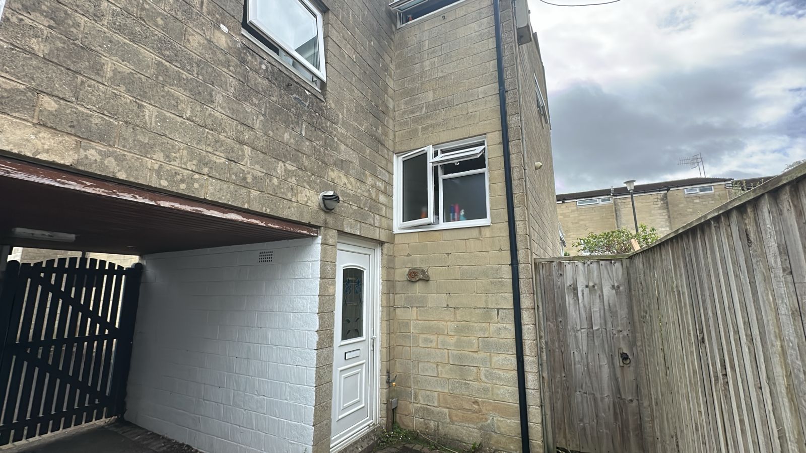 Front of 64 King George's Road, Bath stone with a white door and a 64 plaque